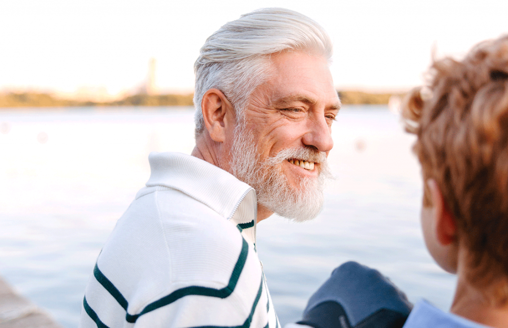 Older men with beard looking over at young boy